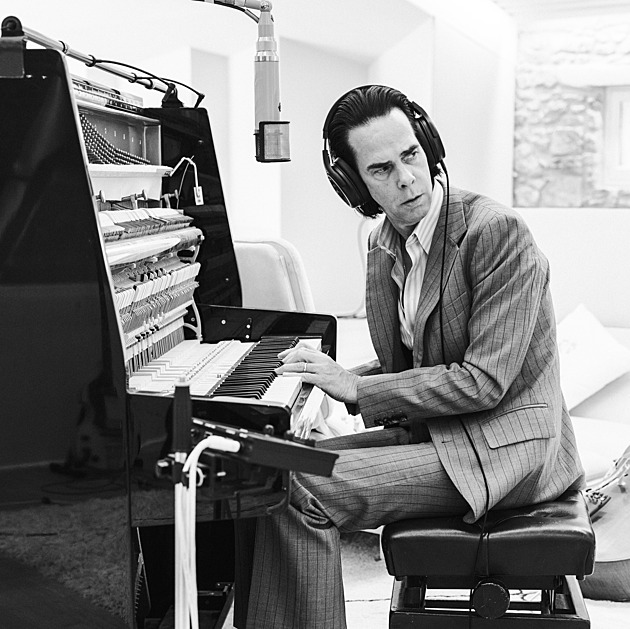 Nick Cave je jako dirigent, řídí kapelu i publikum, líčí jeho kytarista