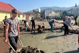 Místo učení práce s lopatou. Studenti z Gymnázia Jeseník pomáhají vyklízet budovu školy po záplavách